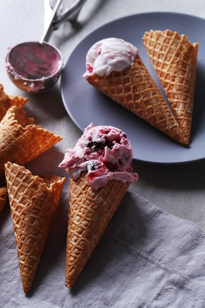 Ice cream cones with berry ice cream and scoop