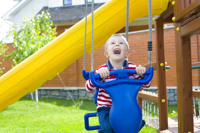 Boy on a swing set with a slide