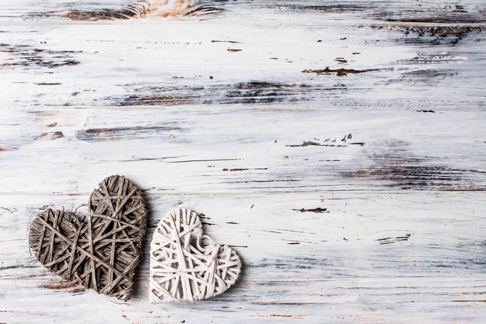 Two Woven Hearts on White Wood Background