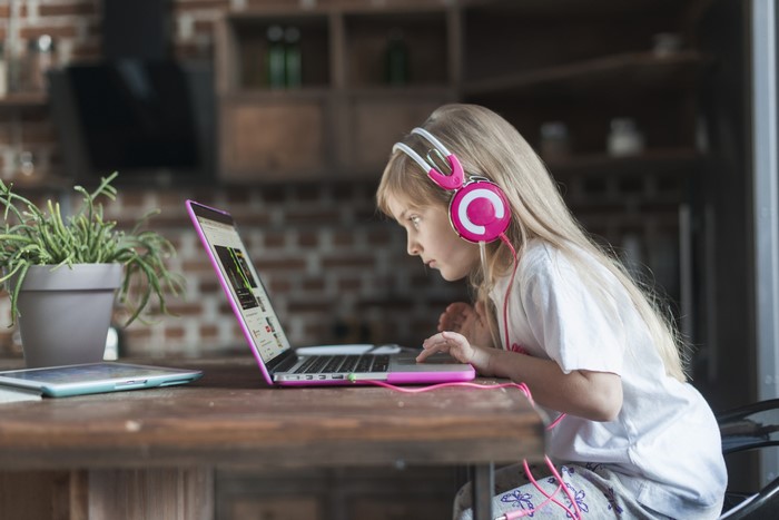 Girl with headphones using a laptop