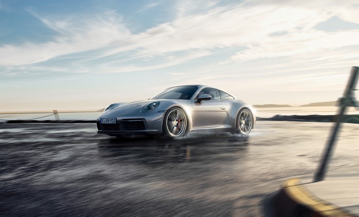 Silver Porsche 911 driving on wet road