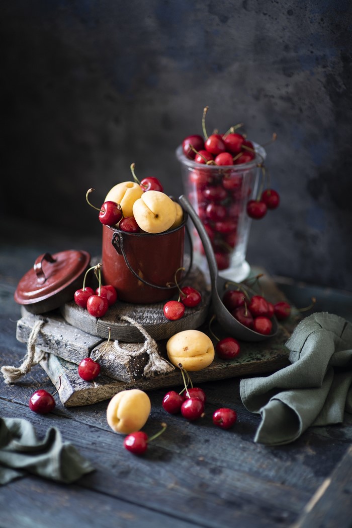 Still life with cherries and apricots in a bucket