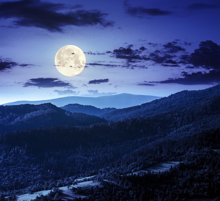 Full moon over mountains at night