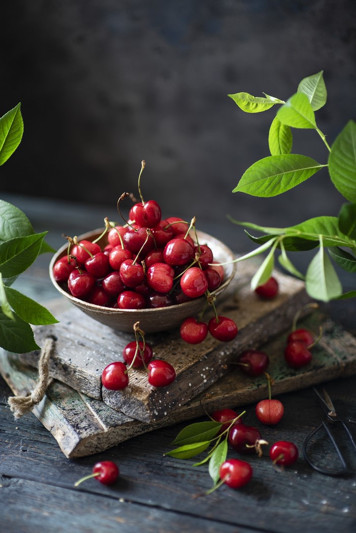 Cherries in a bowl on wooden planks