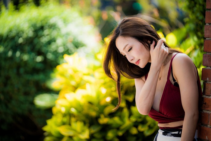 Asian woman with brown hair in a garden