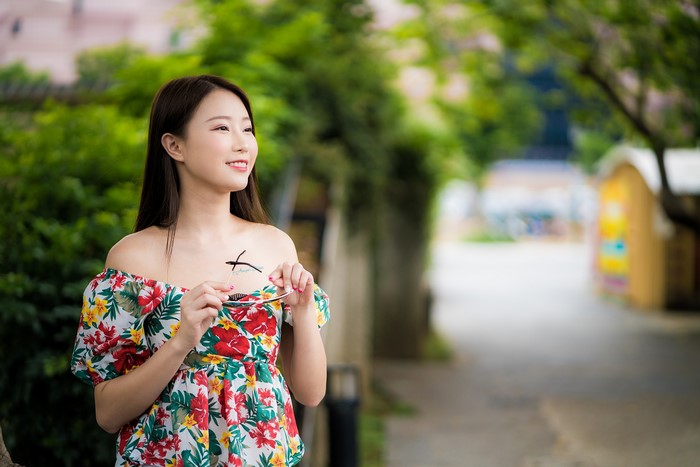 Asian woman in floral dress holding glasses
