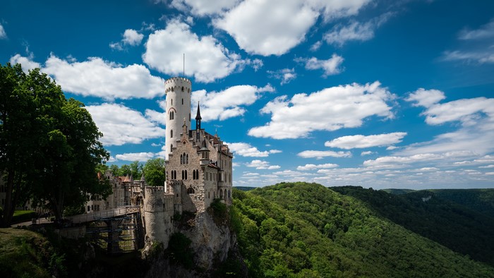 Castle Lichtenstein on a cliff with green forest and blue sky