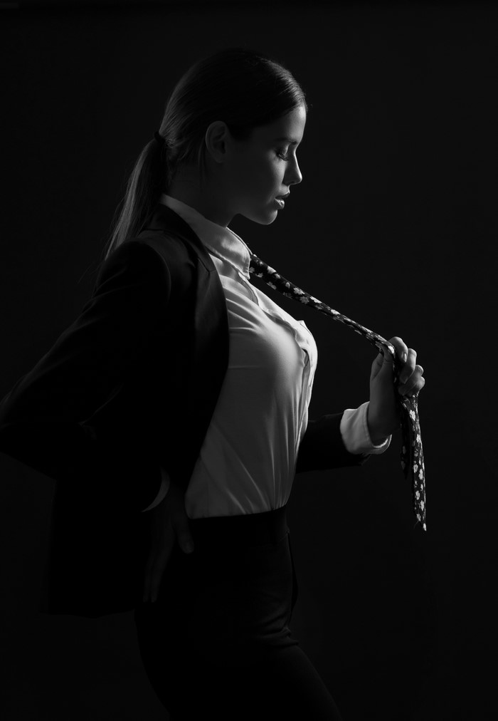 Woman in suit holding a tie
