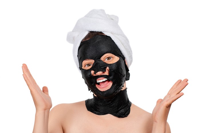 Woman with black face mask and towel on head