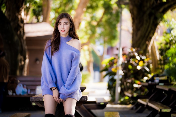 Asian woman with brown hair wearing a purple sweater