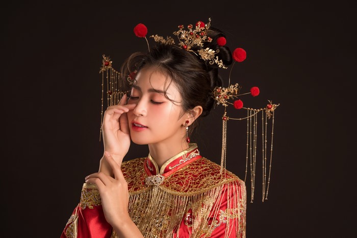 Asian woman in traditional red dress with ornate hairpiece