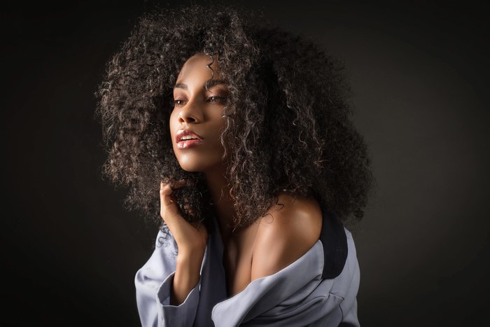 Daniela with curly hair looking to the side