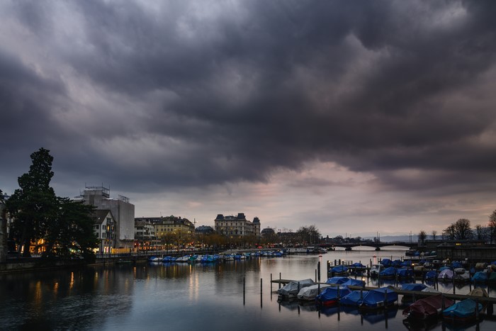 Zurich river with boats and stormy clouds