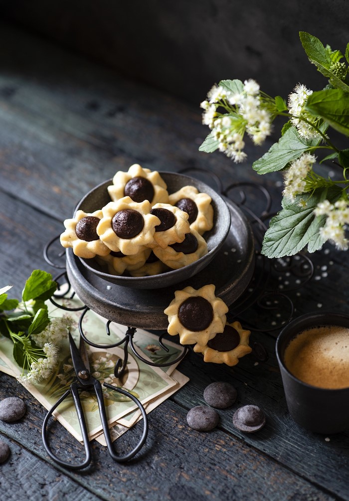 Flower-shaped chocolate cookies on a dark wooden table