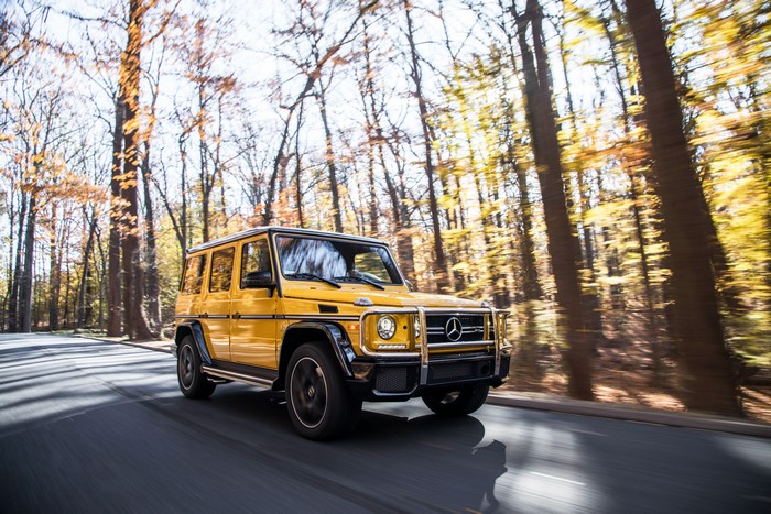 Yellow Mercedes-Benz G63 AMG G-Class SUV driving on road