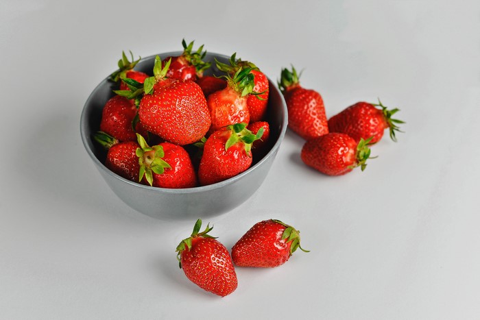 Bowl of fresh strawberries on a gray background