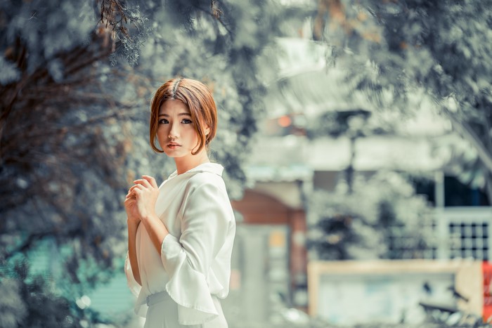 Asian woman with brown hair in white clothing