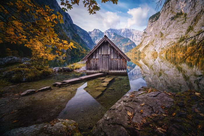 Wooden boathouse on Obersee lake in the German Alps during autumn