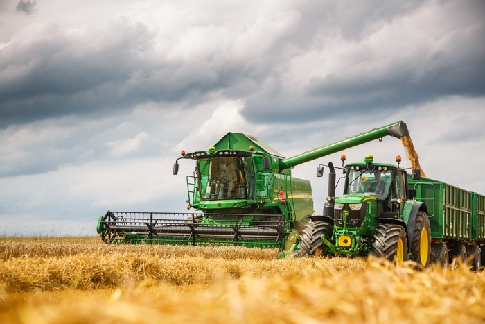 John Deere combine harvester and tractor in a wheat field