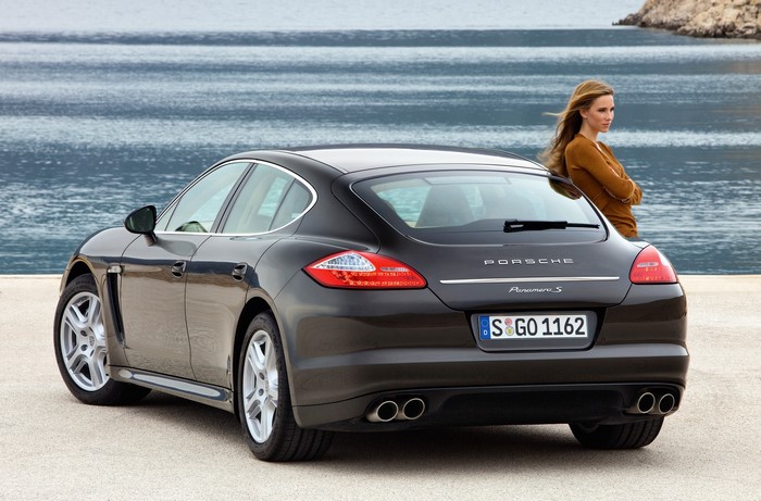 Porsche Panamera S parked by the sea with a woman
