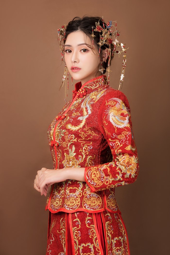 Asian woman in traditional red wedding dress with ornate jewelry