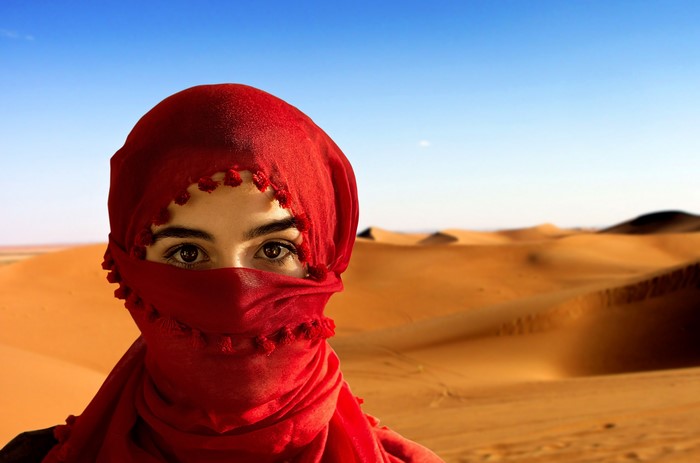 Woman in red hijab in desert