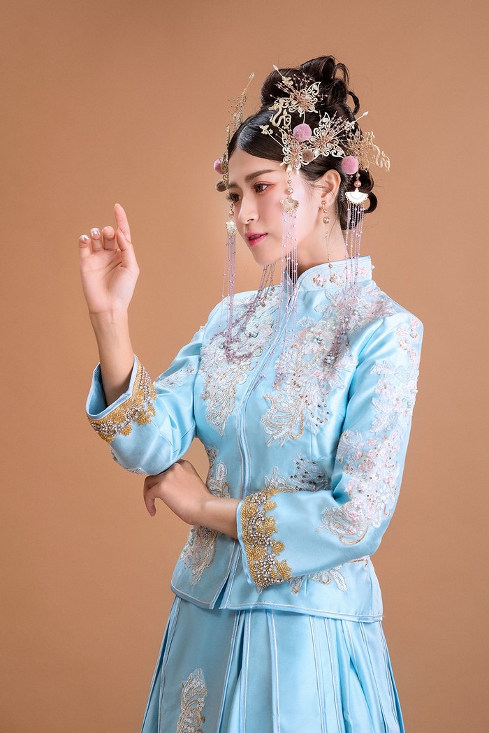 Woman in traditional blue Chinese wedding dress with elaborate headpiece