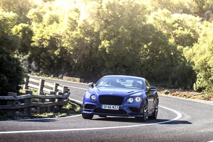 Blue Bentley Continental GT Supersport driving on a winding road