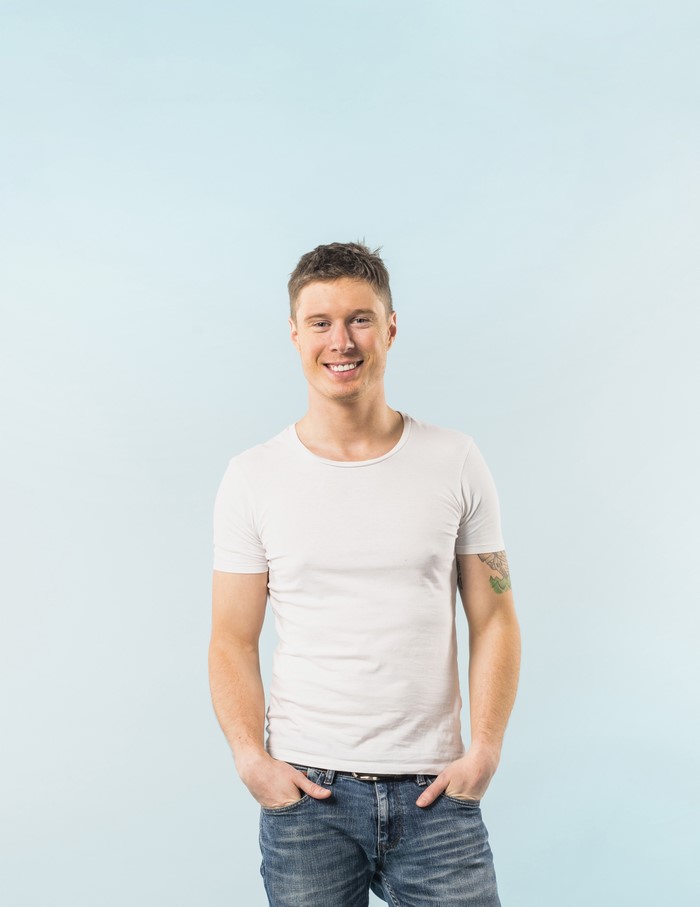 Man in white t-shirt and jeans smiling