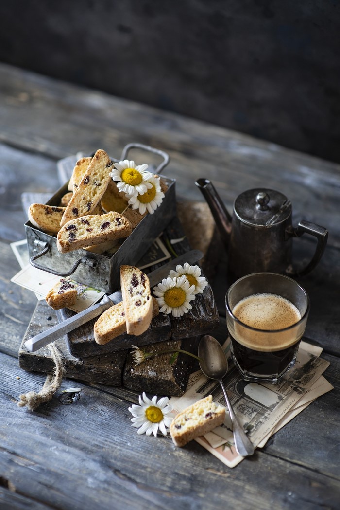 Biscotti with coffee and chamomile flowers on wooden planks