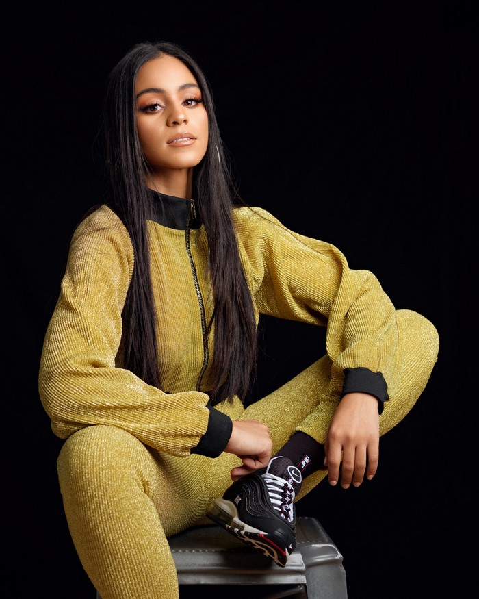 Jaenele sitting in a yellow tracksuit