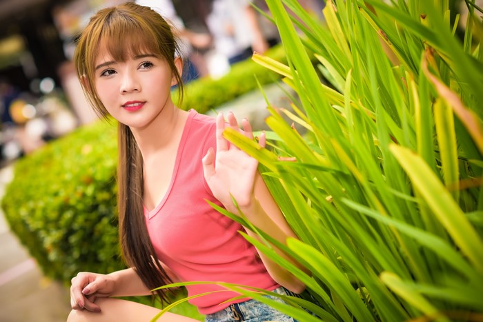 Asian woman with brown hair in pink shirt