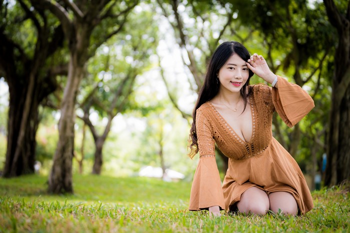 Asian girl in dress sitting on grass
