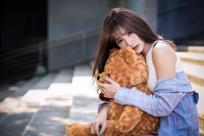 Brunette girl hugging a teddy bear
