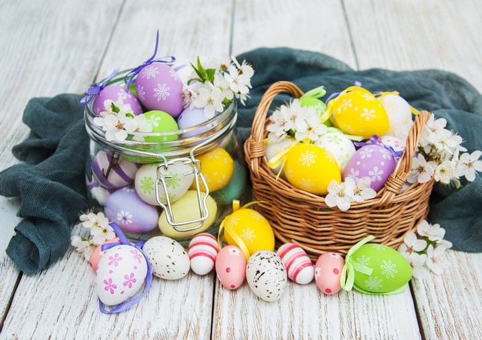 Easter eggs in a jar and basket on wood planks