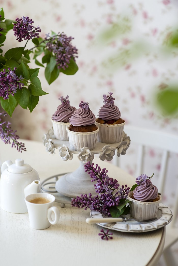 Cupcakes with lilac and coffee on a table