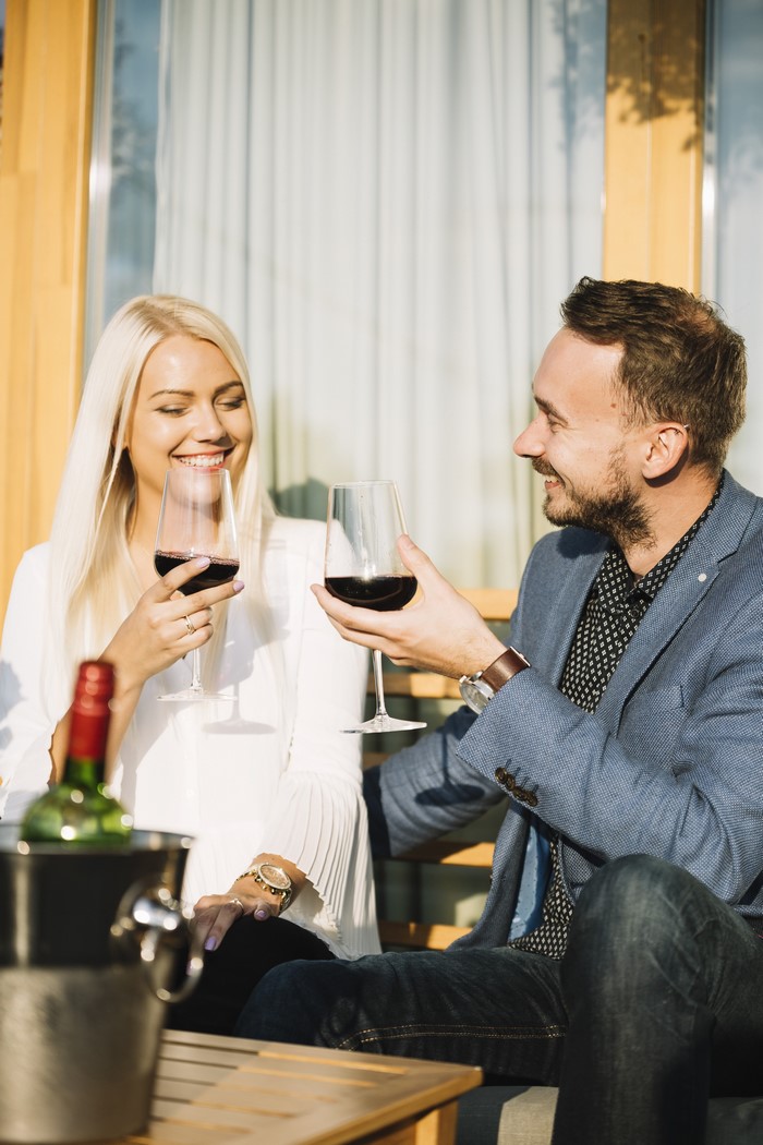 Couple toasting with red wine outdoors