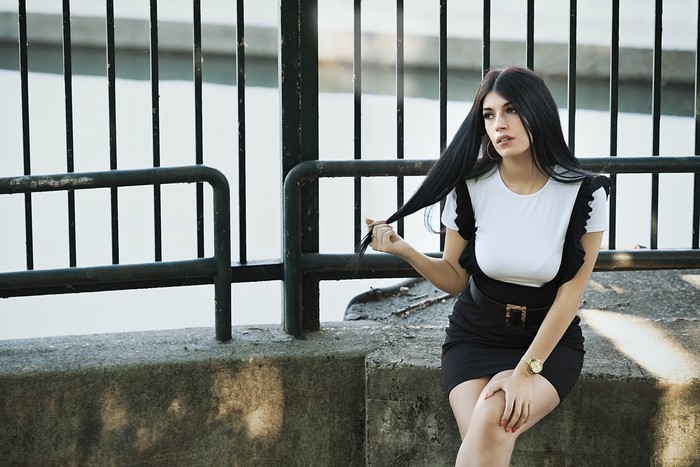 Martina, Brunette girl sitting by a fence
