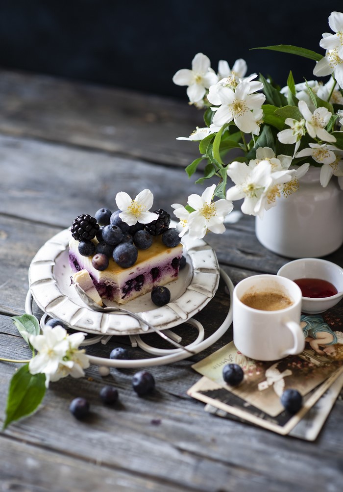 Slice of blueberry cheesecake with berries and coffee
