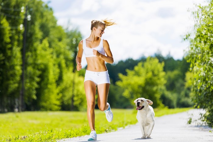 Woman running with a dog on a path