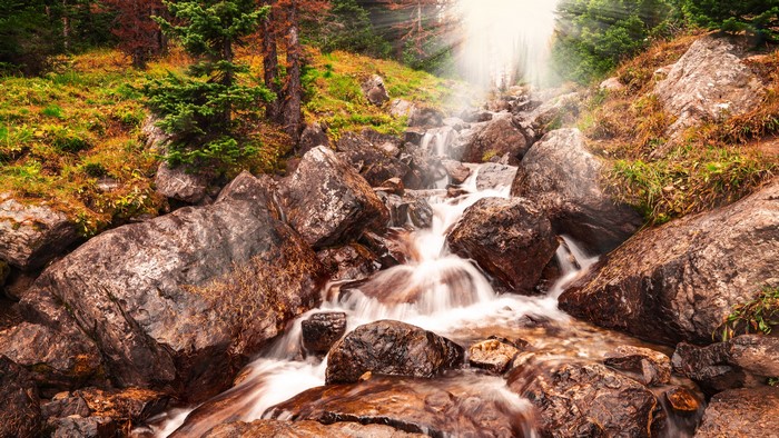 Sunlight Rays Over Rocky Mountain Stream