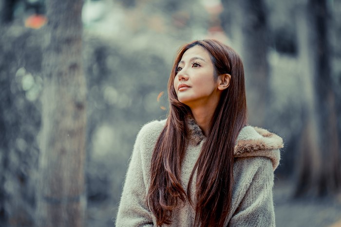 Asian woman with brown hair in a furry coat