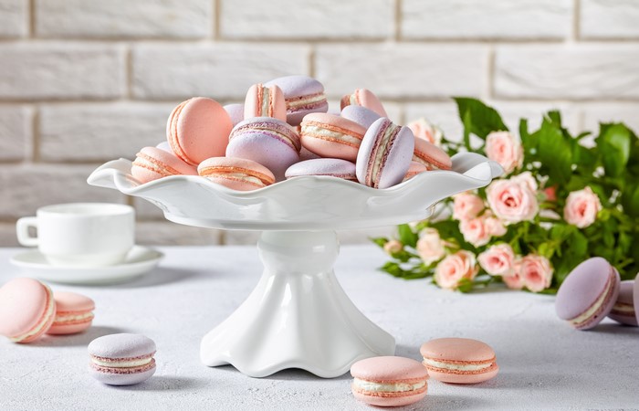Pink and purple macarons on a white cake stand