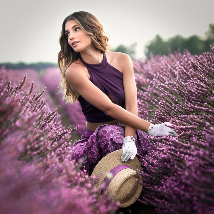 Woman in a lavender field with a hat and gloves