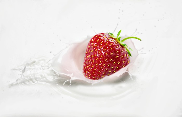 Strawberry splashing into milk