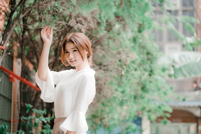Asian woman with brown hair in white shirt