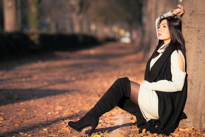 Brunette girl wearing boots in autumn foliage