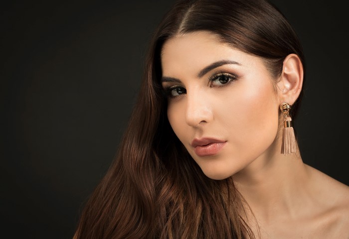 Priscila with brown hair and tassel earrings