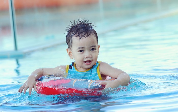 Boy in a swimming pool with a float