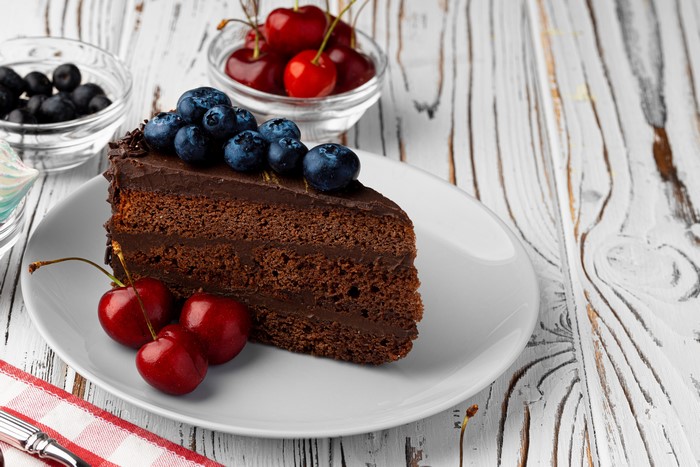 Chocolate cake slice with blueberries and cherries